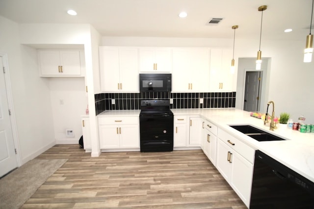 kitchen featuring sink, white cabinetry, hanging light fixtures, decorative backsplash, and black appliances