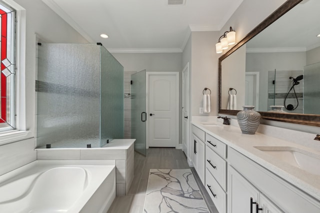 bathroom featuring crown molding, vanity, wood-type flooring, and shower with separate bathtub