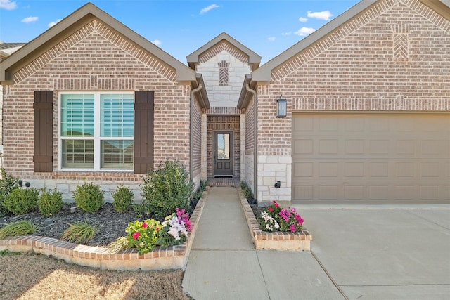 view of front of property featuring stone siding, brick siding, driveway, and an attached garage