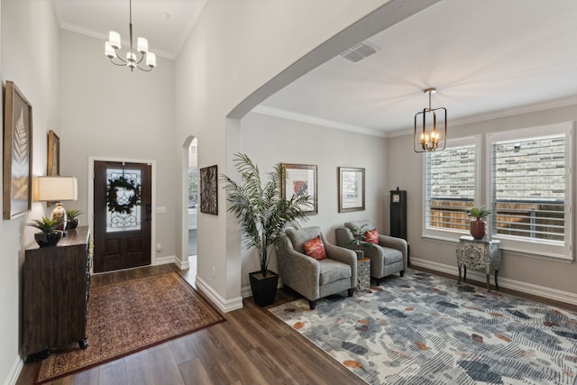 foyer featuring ornamental molding, dark hardwood / wood-style floors, and a notable chandelier