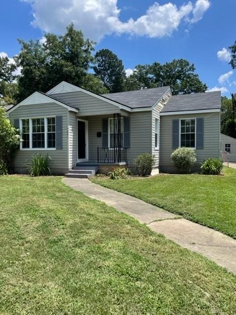 ranch-style home with covered porch and a front lawn