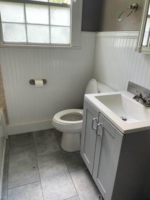 bathroom with tile patterned flooring, vanity, a bath, and toilet