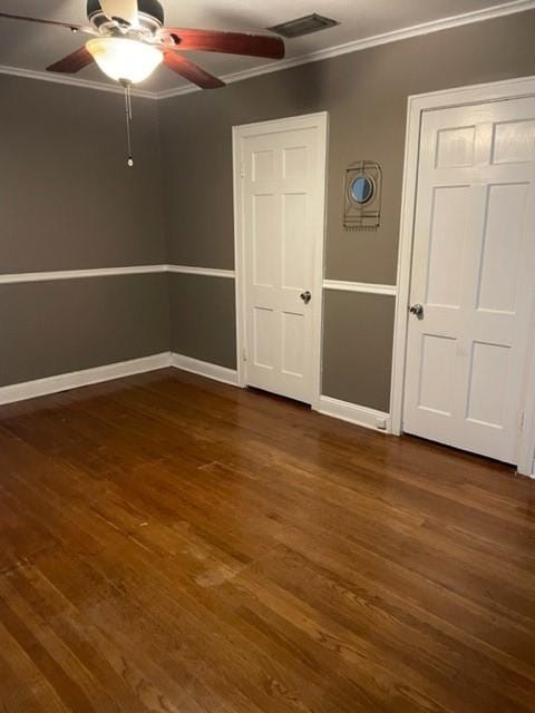 unfurnished bedroom with dark hardwood / wood-style floors, ceiling fan, and crown molding