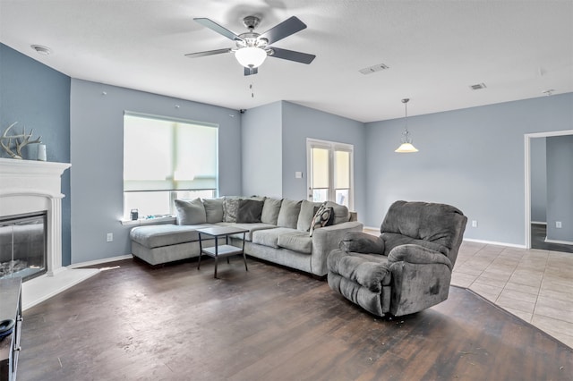 living room featuring a textured ceiling, a healthy amount of sunlight, ceiling fan, and dark hardwood / wood-style flooring