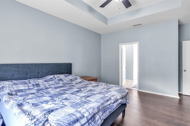 bedroom featuring ceiling fan, a raised ceiling, and dark hardwood / wood-style floors