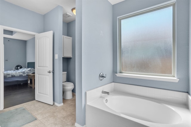 bathroom with tile patterned flooring, a bathtub, and toilet