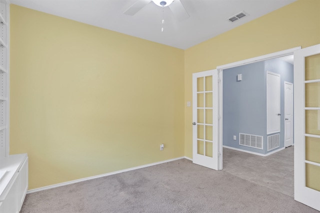 spare room with light carpet, ceiling fan, and french doors