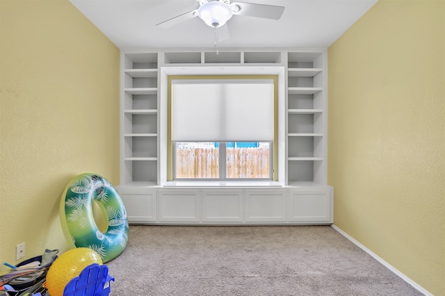 interior space with carpet flooring and ceiling fan