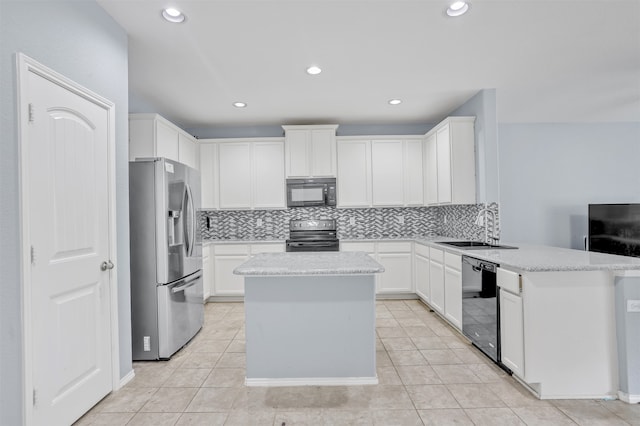 kitchen with tasteful backsplash, sink, kitchen peninsula, white cabinets, and black appliances