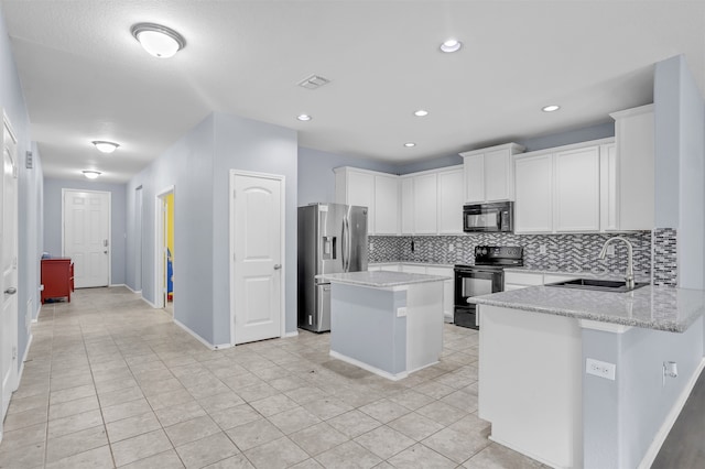 kitchen with black appliances, light stone counters, decorative backsplash, a center island, and sink