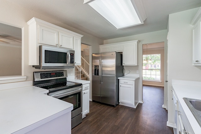 kitchen featuring appliances with stainless steel finishes, dark hardwood / wood-style flooring, and white cabinets