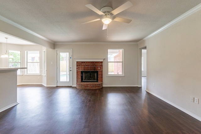 unfurnished living room with ornamental molding, dark hardwood / wood-style floors, ceiling fan, and a healthy amount of sunlight