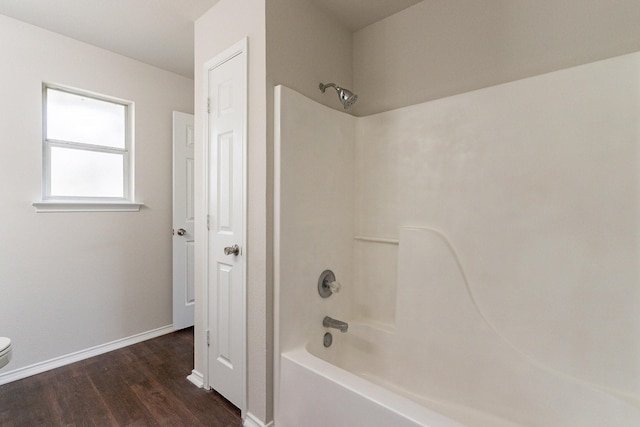 bathroom featuring shower / bathing tub combination, wood-type flooring, and toilet