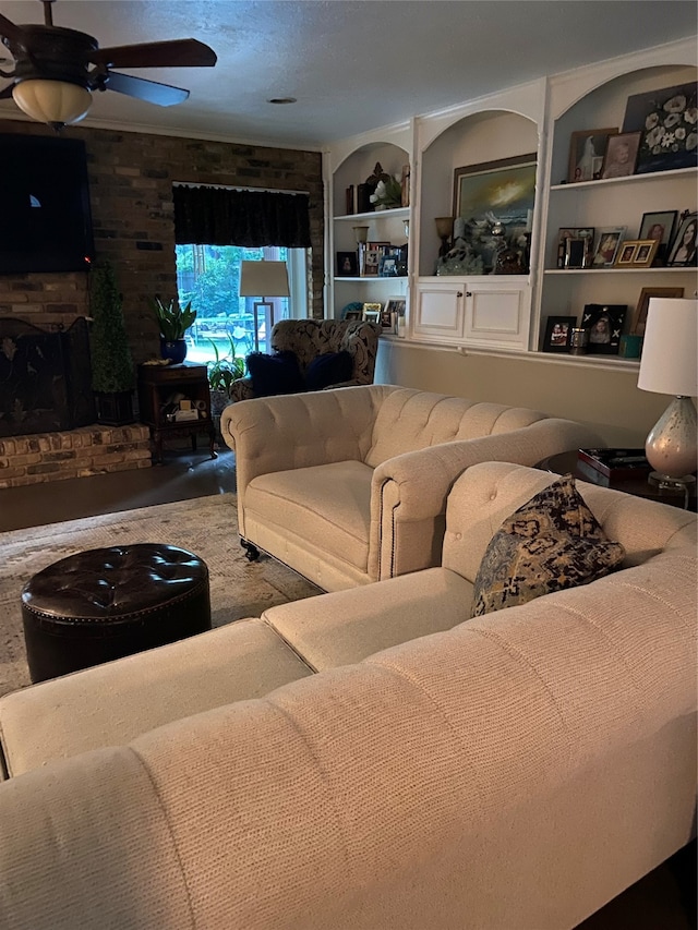 living room with brick wall, built in features, a fireplace, and ceiling fan