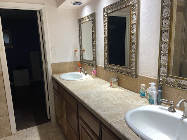 bathroom featuring tile patterned floors, decorative backsplash, and dual bowl vanity