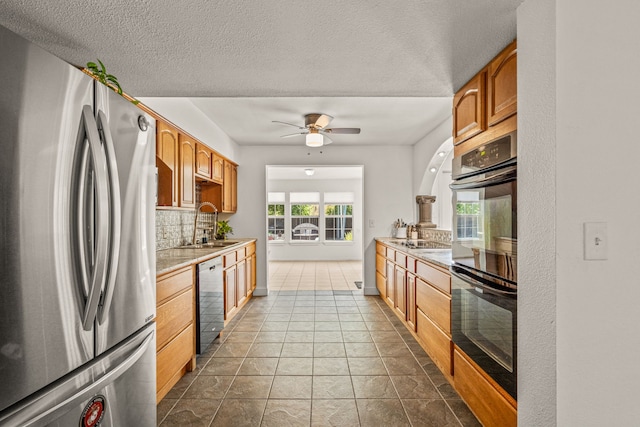 kitchen featuring ceiling fan, black double oven, stainless steel refrigerator, dishwasher, and tile patterned flooring