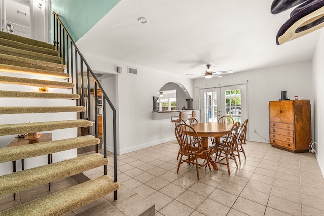 tiled dining area featuring ceiling fan and french doors