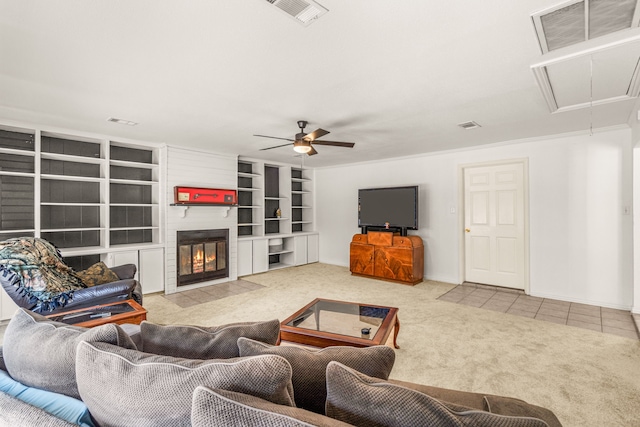 living room featuring ceiling fan, built in features, a fireplace, and light colored carpet