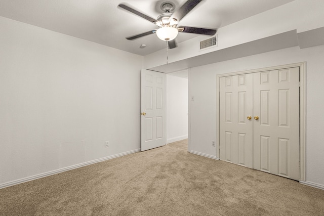 unfurnished bedroom with ceiling fan, light colored carpet, and a closet