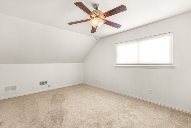 additional living space featuring ceiling fan, vaulted ceiling, and light colored carpet