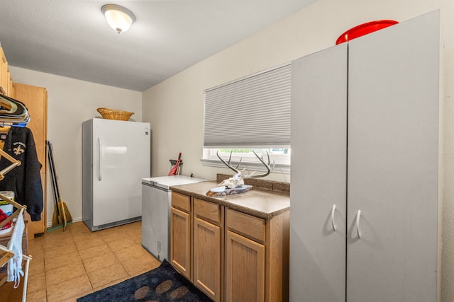 kitchen with light tile patterned flooring and white fridge