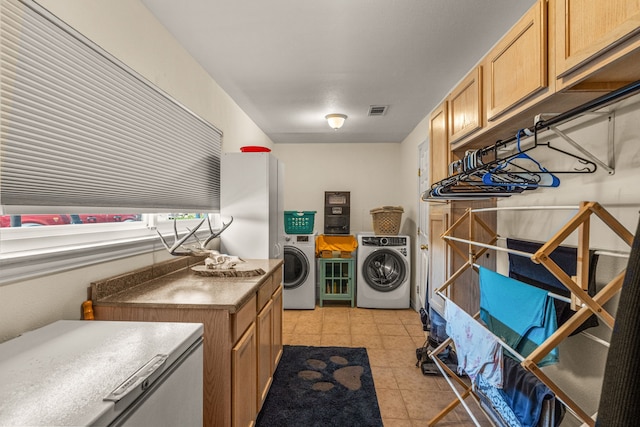 clothes washing area featuring light tile patterned floors and washer and dryer