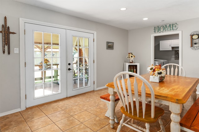 tiled dining space with washer / clothes dryer and french doors