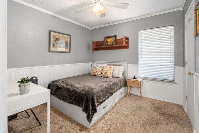 bedroom with a textured ceiling, light colored carpet, ornamental molding, and ceiling fan