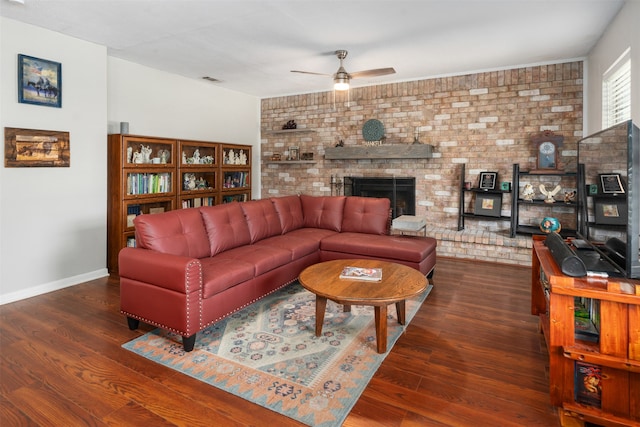 living room featuring brick wall, dark hardwood / wood-style flooring, a fireplace, and ceiling fan