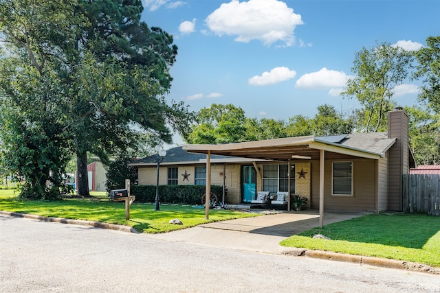 ranch-style home featuring a carport and a front lawn