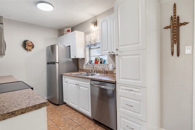 kitchen with light tile patterned floors, white cabinetry, appliances with stainless steel finishes, and sink