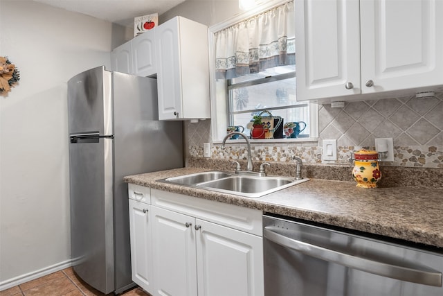 kitchen with white cabinetry, stainless steel appliances, tasteful backsplash, and sink