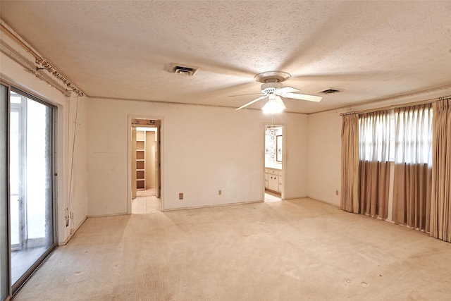 carpeted spare room with ceiling fan and a textured ceiling