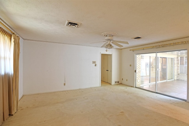 carpeted spare room with ceiling fan and a textured ceiling