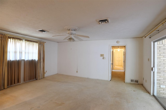 carpeted empty room featuring a textured ceiling and ceiling fan