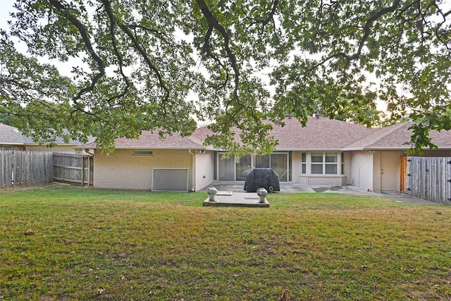 back of property featuring a patio area and a yard