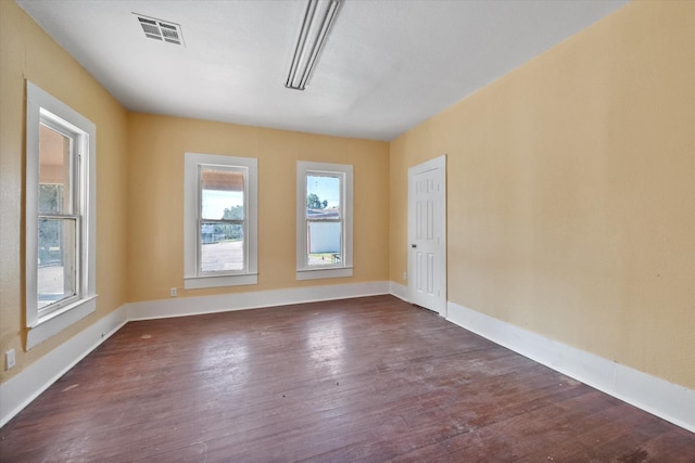 unfurnished room with a wealth of natural light and dark wood-type flooring