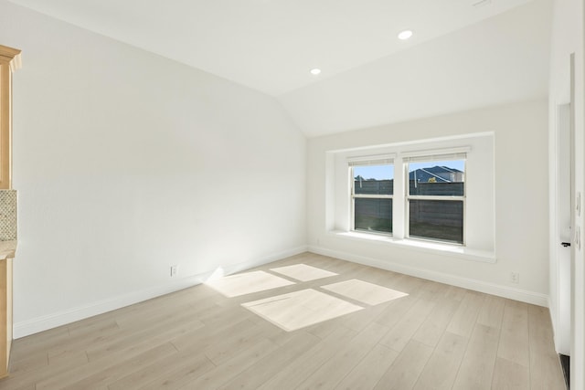 unfurnished room with light hardwood / wood-style flooring and vaulted ceiling