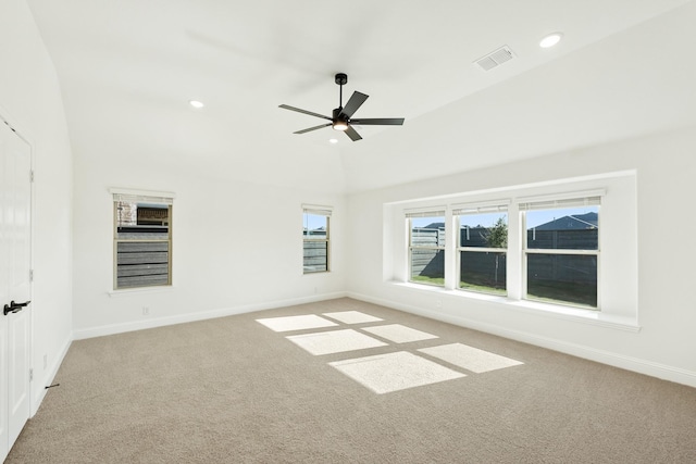 spare room featuring ceiling fan, light carpet, and vaulted ceiling