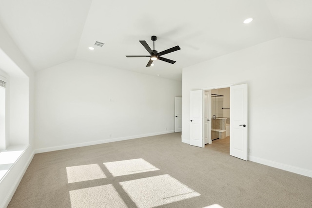 unfurnished bedroom with ceiling fan, light colored carpet, and vaulted ceiling