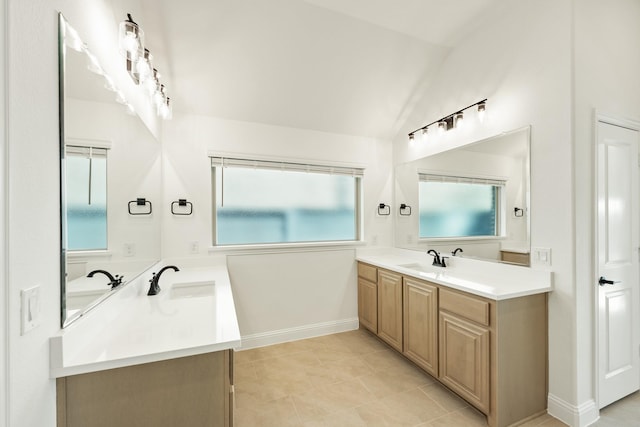 bathroom with tile patterned flooring, vanity, and lofted ceiling