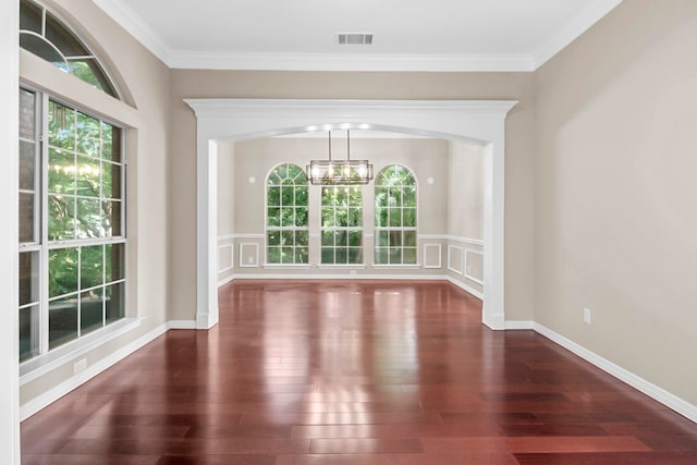 unfurnished dining area with crown molding, dark hardwood / wood-style flooring, a wealth of natural light, and an inviting chandelier