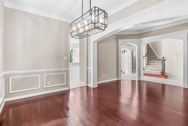 unfurnished dining area featuring hardwood / wood-style floors, crown molding, and a chandelier