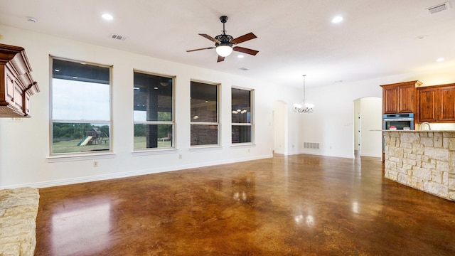 unfurnished living room with ceiling fan with notable chandelier