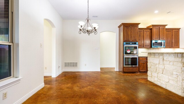 kitchen featuring stainless steel appliances, a chandelier, hanging light fixtures, and backsplash