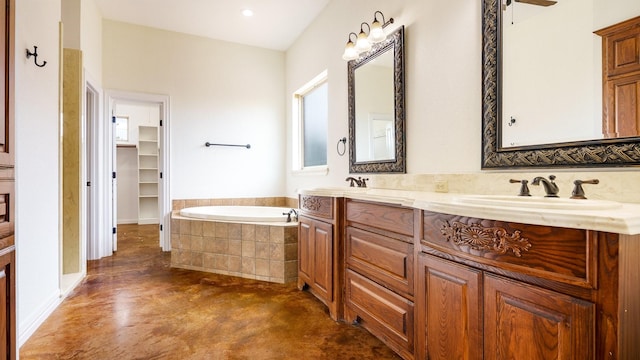 bathroom with a relaxing tiled tub, vanity, and concrete flooring