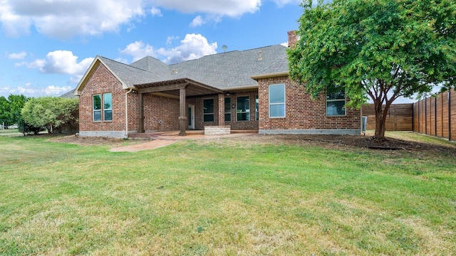 rear view of house with a patio area and a lawn