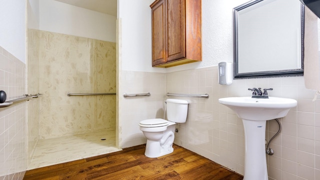 bathroom with wood-type flooring, sink, tile walls, and toilet