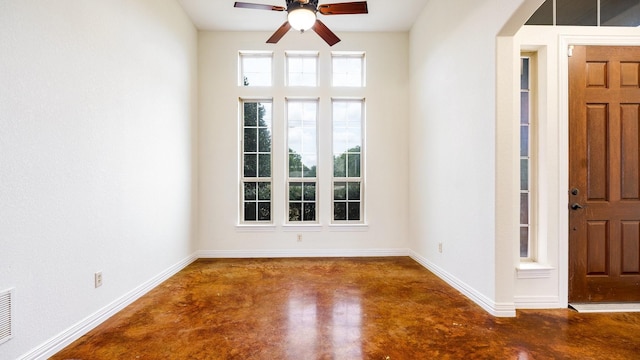 interior space featuring ceiling fan and concrete flooring