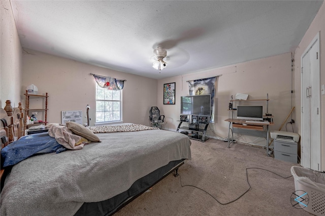 bedroom featuring ceiling fan, a textured ceiling, and carpet flooring